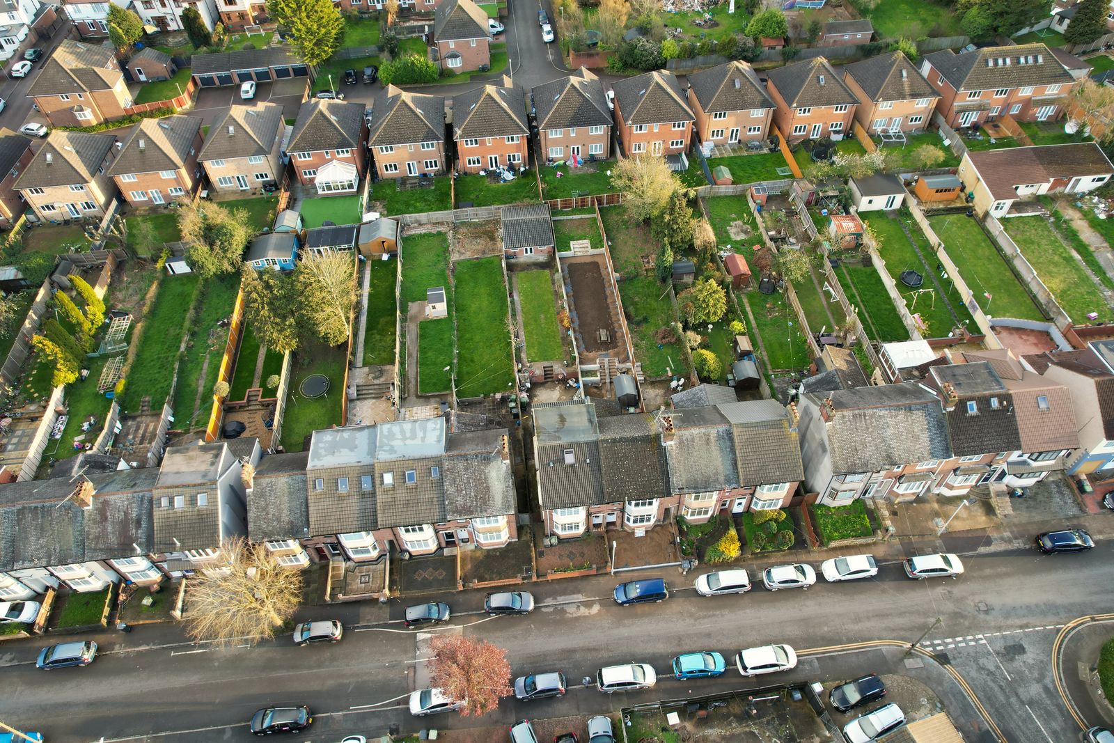 An aerial view of rows of terraced houses with long back gardens between them