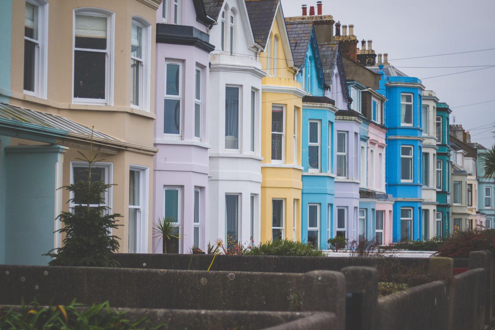 A row of terraced houses painted in pale pastel colours