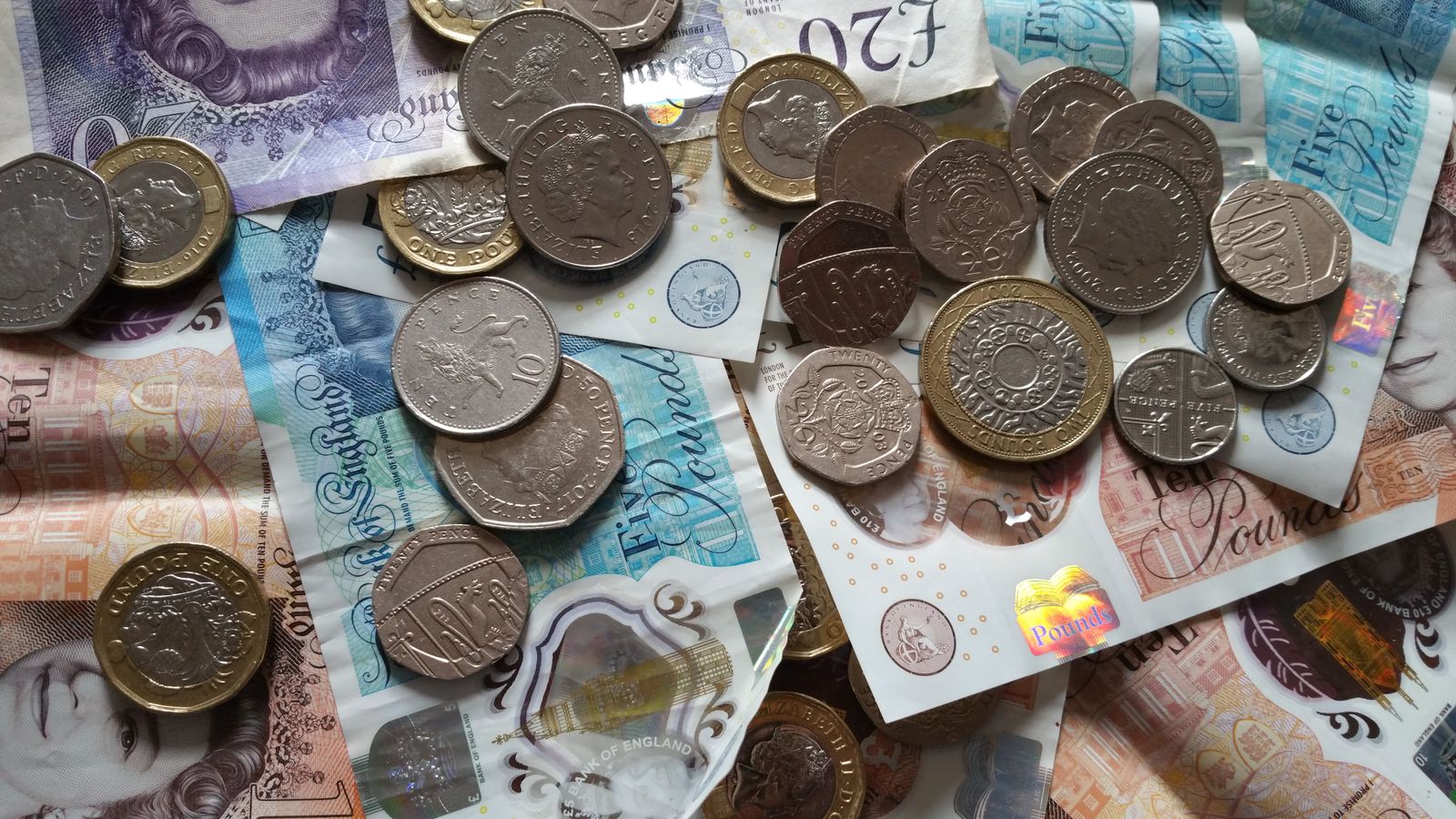 British coins and banknotes spread across a surface